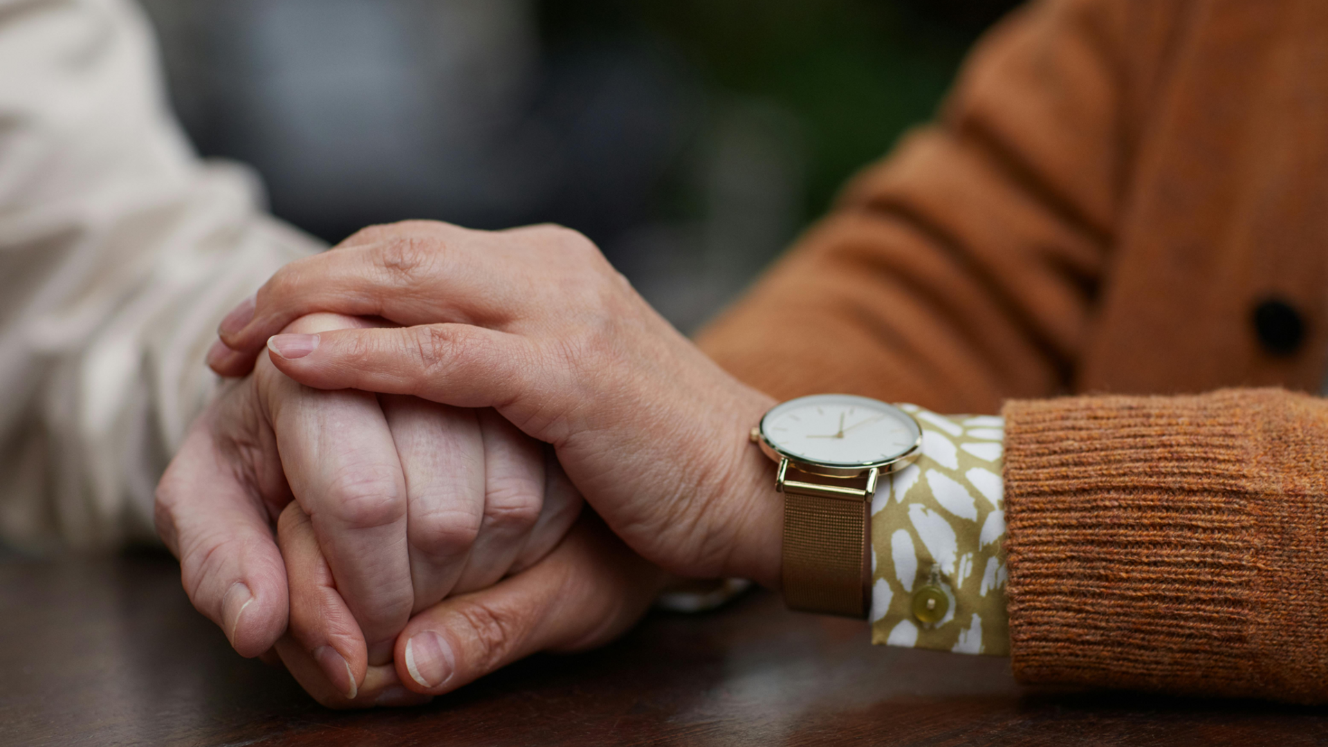 Palliative Pflege Das Bild zeigt zwei sich haltende Hände. anhand der Hände ist zu erkennen, dass es ältere Mendschen sind.